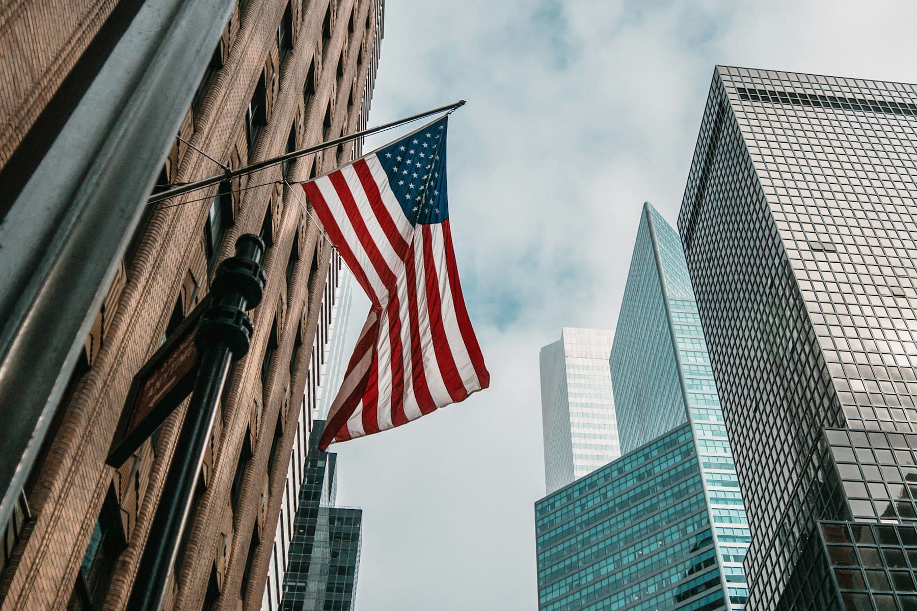 An American flag flying between city buildings