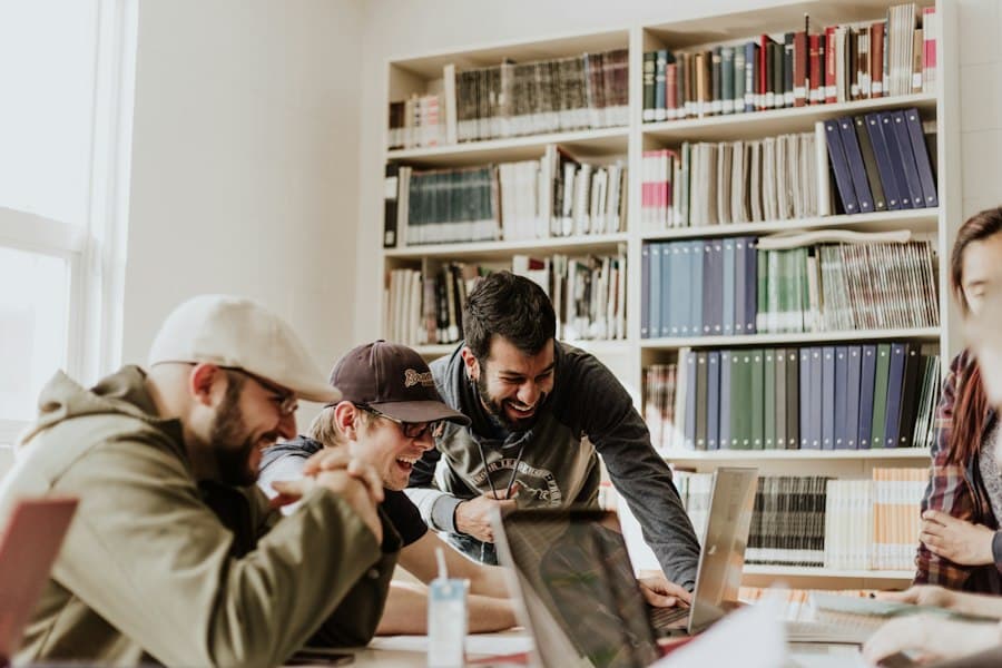 A group of people laughing while working together at a laptop
